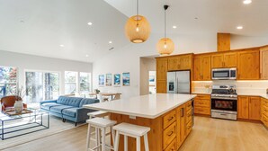 A modern kitchen with wooden cabinets, a large island, and stainless steel appliances. - Golf & Hike! Home in Lake Almanor West Community (Chester)