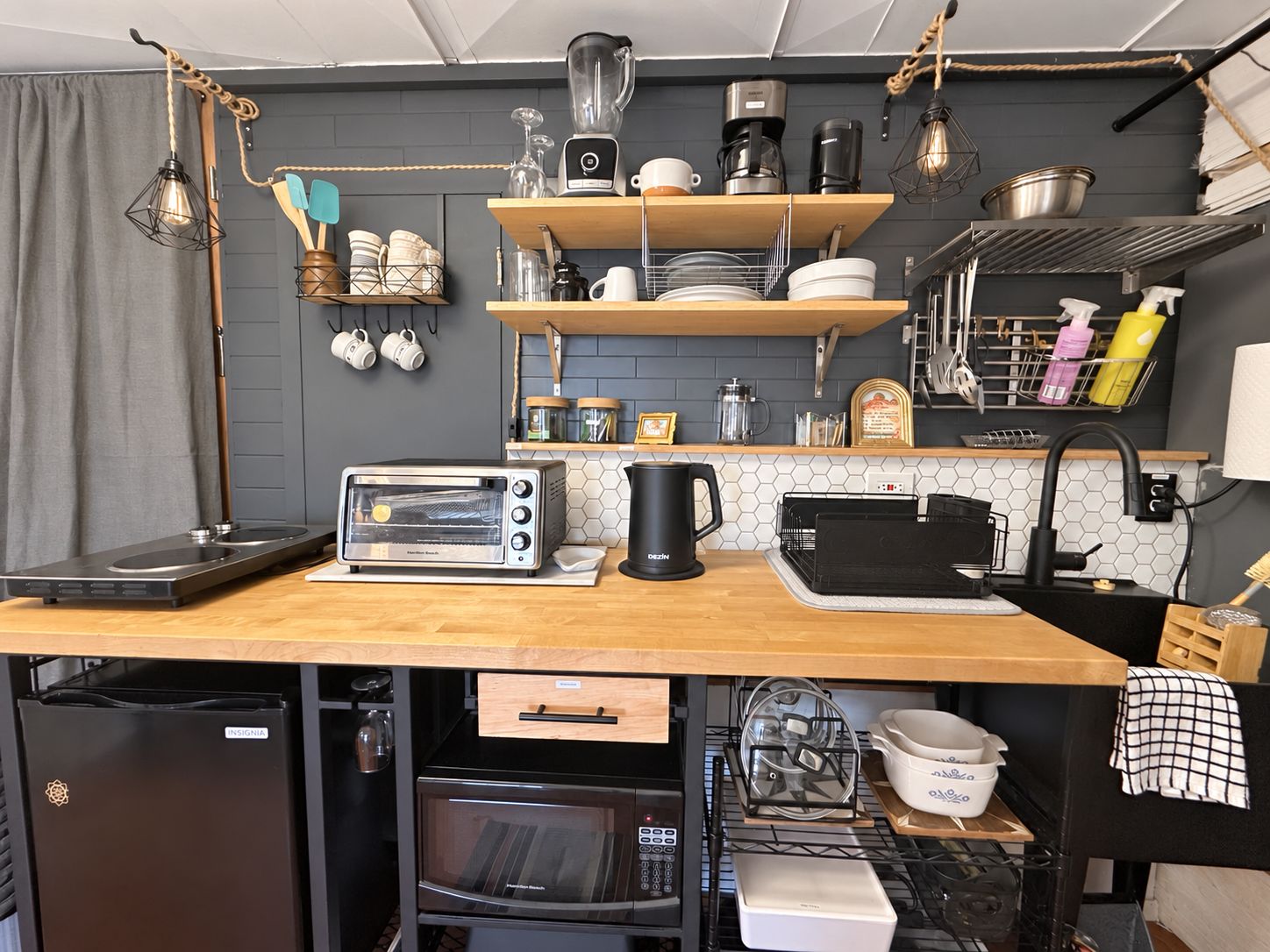 A compact kitchen with a built-in oven, a toaster, and a coffee maker on the counter.