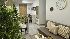 A modern living room with a sofa, coffee table, and decorative items. There is a ceiling fan, a clock, and a plant. - Holiday and rest apartment near the sea (Cartagena de Indias)