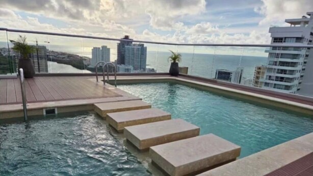 A rooftop pool with steps leading into the water, surrounded by a glass balustrade. - Holiday and rest apartment near the sea (Cartagena de Indias)