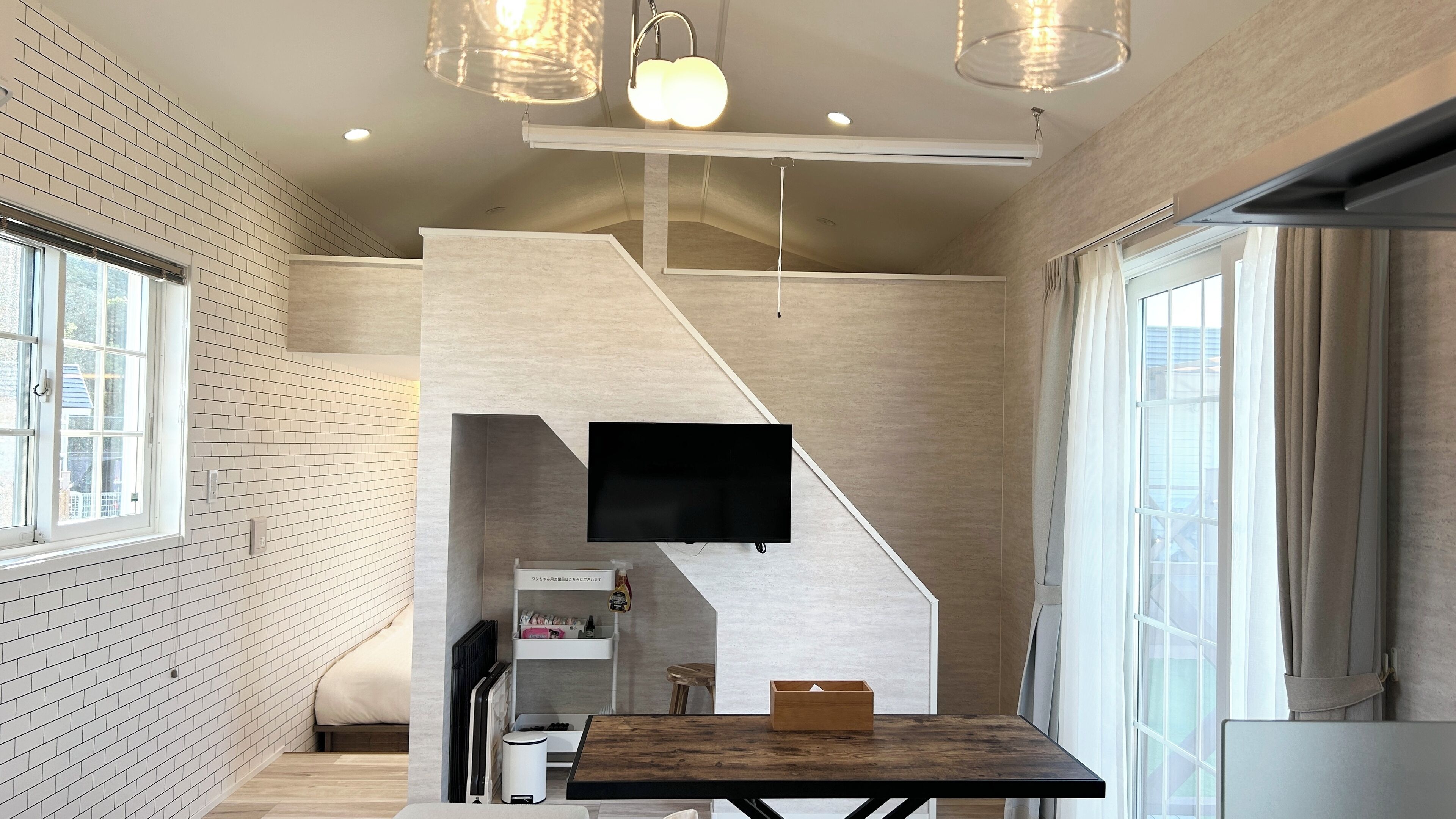 Un interior moderno con una escalera, un televisor de pantalla plana y una zona de comedor.