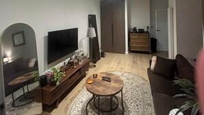 Un soggiorno moderno con una TV a schermo piatto, un tavolino da caffè e un divano.