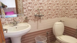 A bathroom with a white sink, toilet, and shower. - Hotel Ganga vardan (Rishikesh)