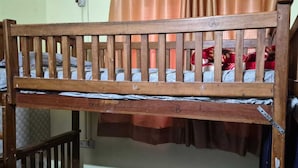A wooden bunk bed with a metal frame, a mattress, and a blanket. - Hotel Ganga vardan (Rishikesh)