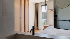 A modern bathroom with a large sink, wooden sliding doors, and a view of a balcony with a table and chairs. - Pine View Bay, Hvar Island (Stari Grad)