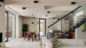 A modern living room with a glass staircase, a dining area with a table and chairs, and a large window providing natural light. - Pine View Bay, Hvar Island (Stari Grad)