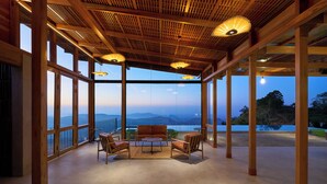 A spacious balcony with wooden flooring, large windows, and a view of the mountains. - Wishing Tree Boutique Resort Haputale (Haputale)
