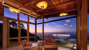 A spacious room with large windows, wooden ceiling, and leather furniture. - Wishing Tree Boutique Resort Haputale (Haputale)