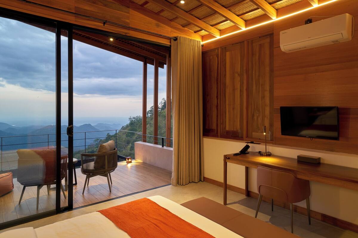 A modern room with a large window, wooden ceiling, and a flat-screen TV.