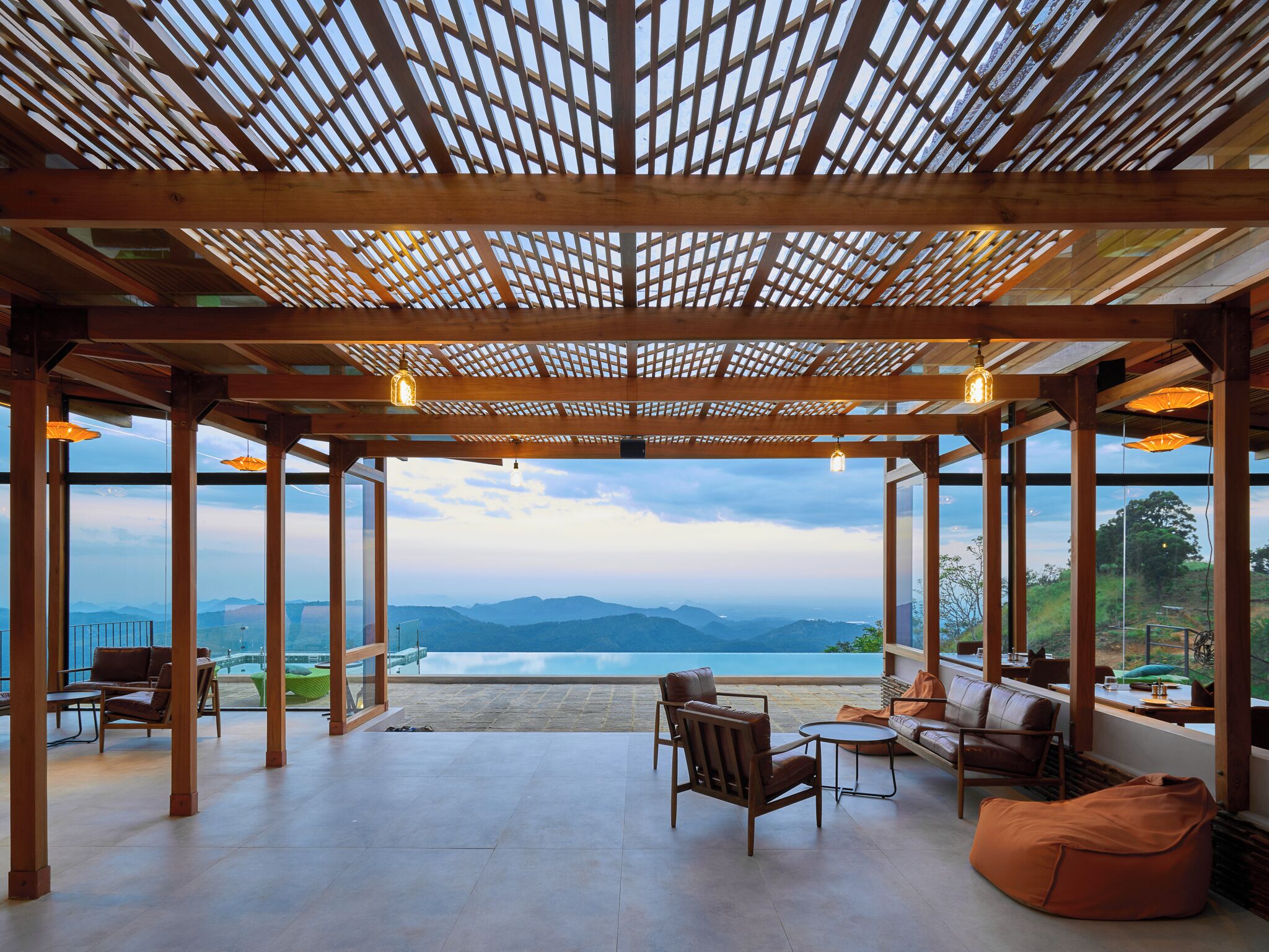 A covered outdoor seating area with a view of a mountainous landscape.