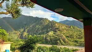 A view from a balcony overlooking a lush valley with mountains in the background. - The Gangotri Homestay By Preet rS (Rajgarhi)