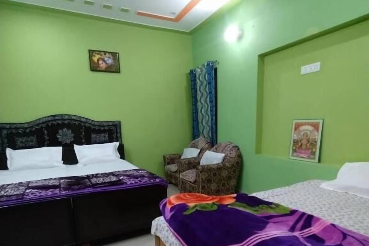 Un dormitorio con dos camas, ventilador de techo y paredes verdes.