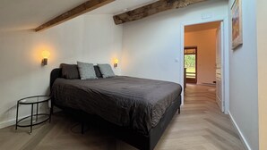 Une chambre à coucher avec un lit, une table ronde et une lucarne.