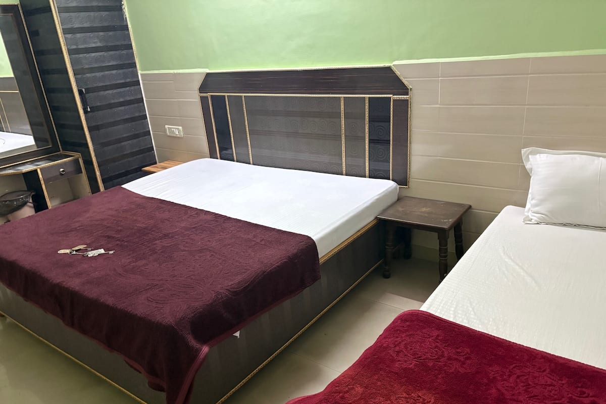 Un dormitorio con cama, mesita de noche y silla.
