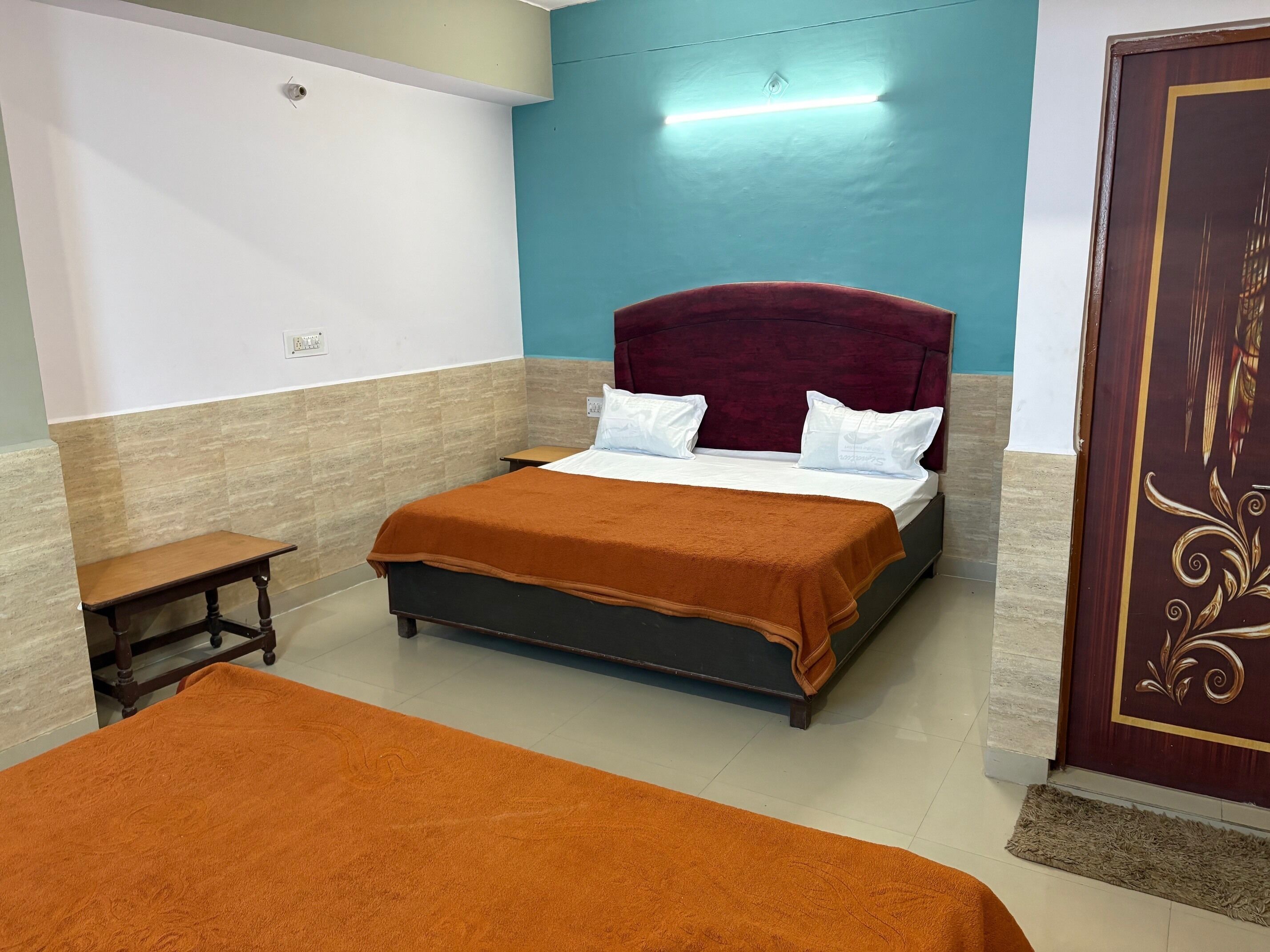A bedroom with a bed, a bench, and a door.