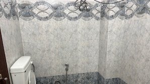Ein Badezimmer mit Toilette, Dusche und Marmorfliesen.