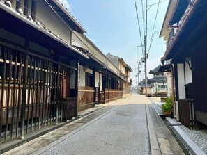 A traditional Japanese street with wooden buildings, a clear sky, and a paved road. - A traditional Japanese house available for private rentalImmerse yourself in Japan hist / Kaizuka City Ōsaka (Kaizuka City)