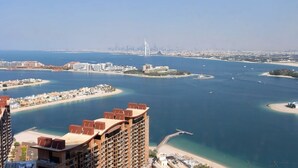 Un paisaje urbano costero con un puente destacado, varias islas y un edificio alto con terraza en la azotea.