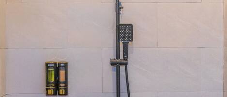 A shower with a handheld attachment, a handheld showerhead, and a wall-mounted control panel.