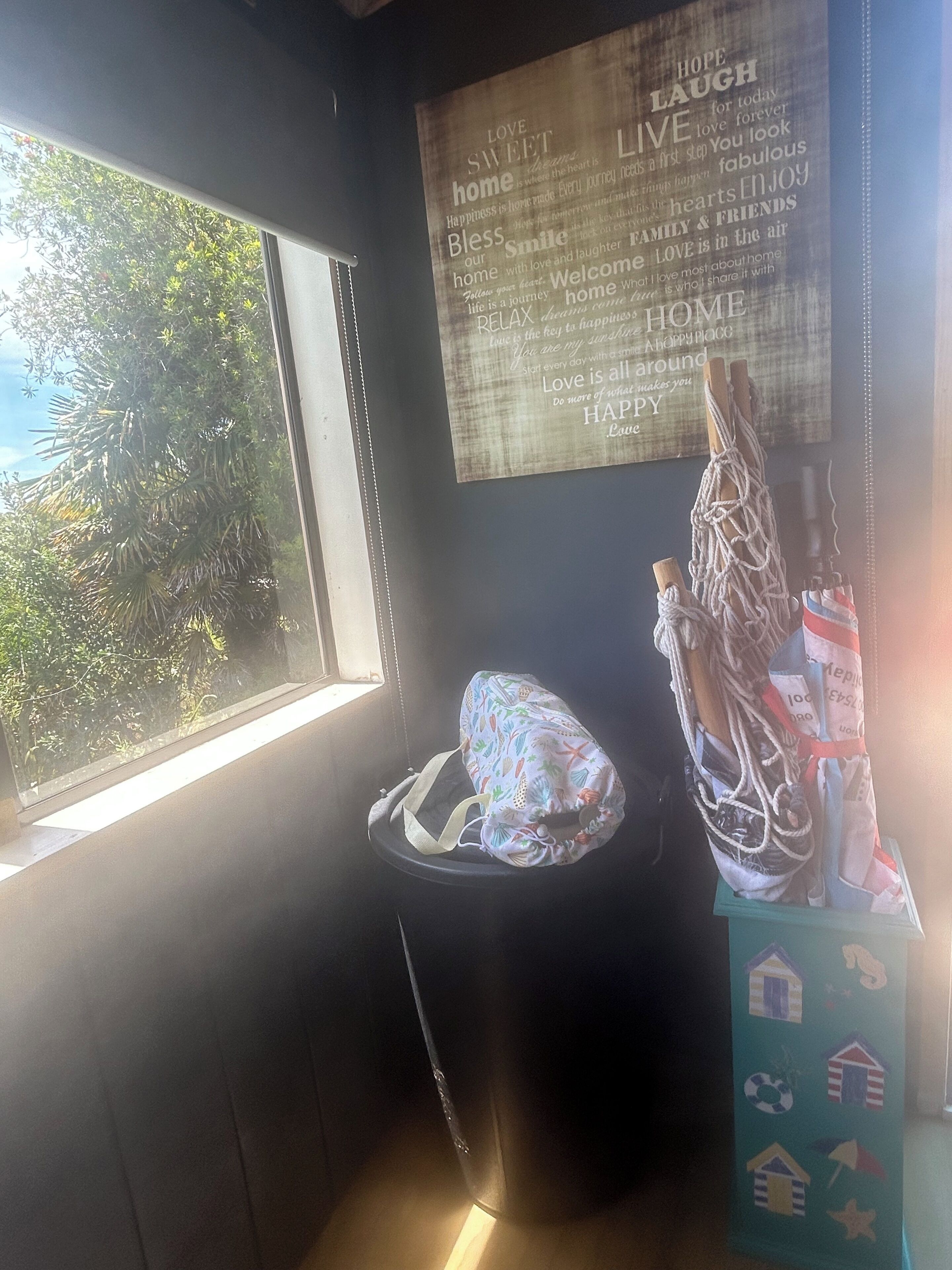 A room with a window, a wall with motivational quotes, a hammock, and a beach-themed wall hanging.