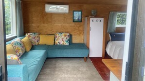 A cozy room with a sectional sofa, a wardrobe, and a bed.