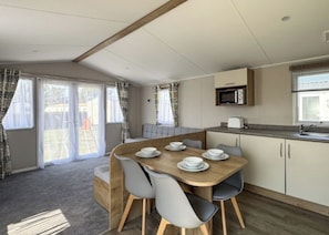 A compact kitchen with a dining table set for four, a microwave, and a toaster.