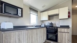 Eine kleine Küche mit Mikrowelle, Toaster, Spüle und Herd.