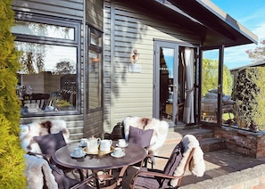A patio with a table set for tea, a dog, and a sign reading 'Bruce'. - 2 bedroom accommodation in Easingwold (Easingwold)