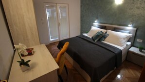 Een slaapkamer met een bed, nachtkastjes, een bureau en een stoel.