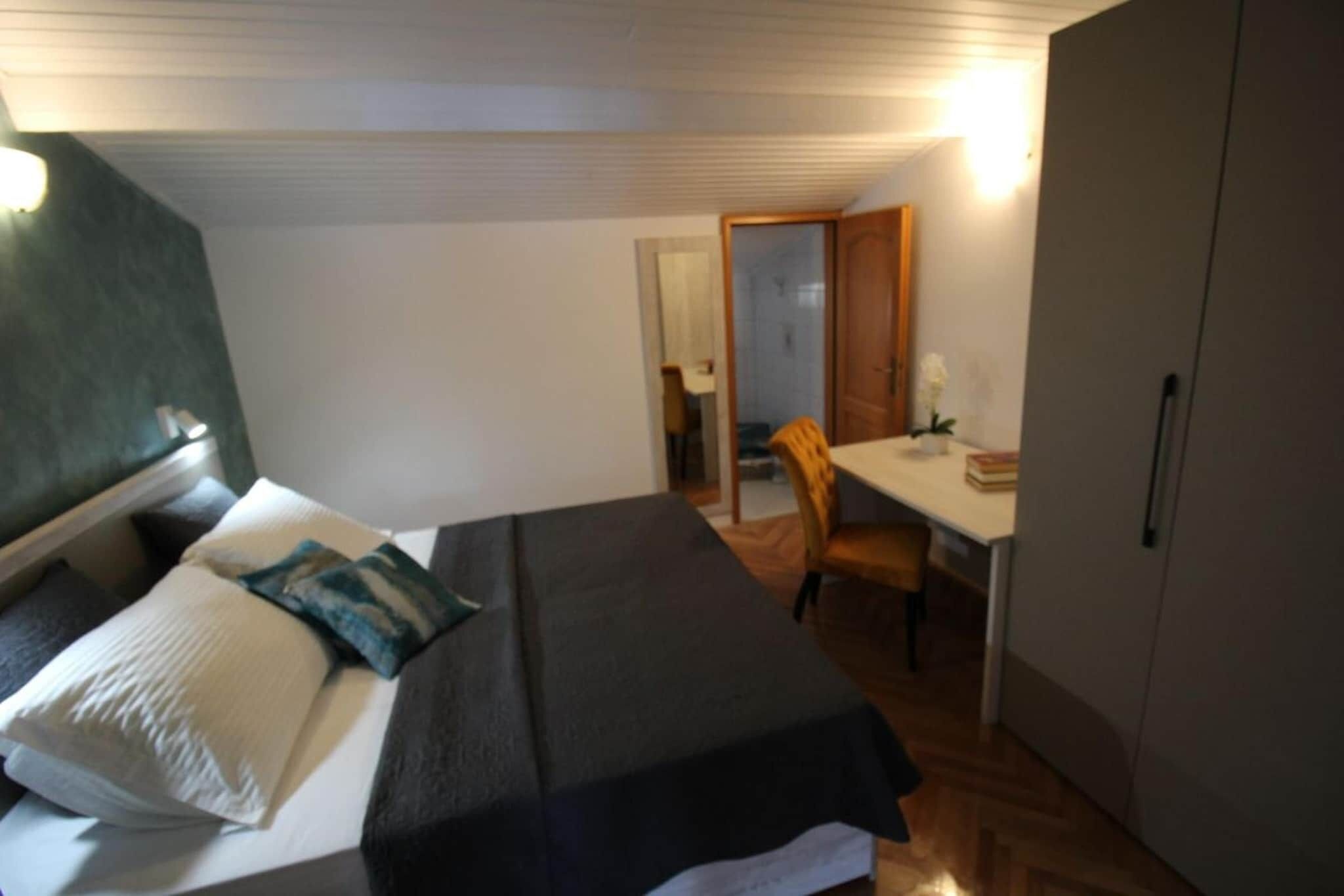 A room with a bed, a desk, and a wardrobe.