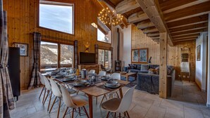 A wooden interior with a dining area, kitchen, and living space. - Chalet Renard Roux - La Tzoumaz, 4 Vallees (La Tzoumaz)