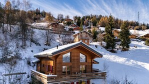 A wooden chalet with a balcony, surrounded by snow-covered trees and a mountainous backdrop. - Chalet Renard Roux - La Tzoumaz, 4 Vallees (La Tzoumaz)