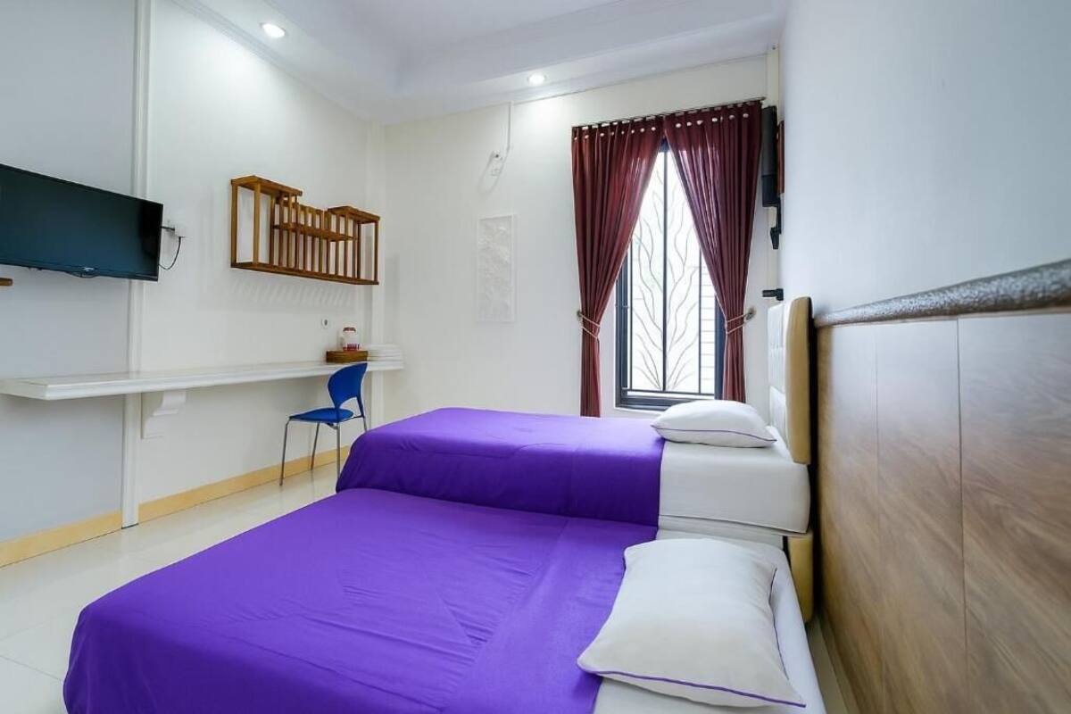 Una habitación con una cama, un escritorio y una silla.