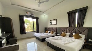 Ein Hotelzimmer mit zwei Betten, einem Schreibtisch und einem Deckenventilator.
