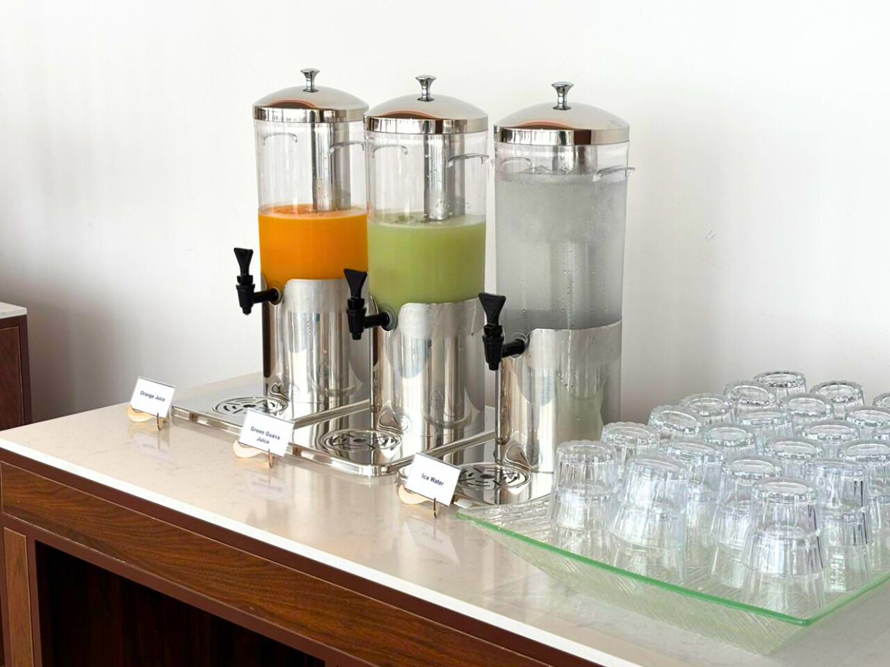 Eine Getränkestation mit drei Spendern, beschriftet mit 'Chai Tee', 'Grüner Tee' und 'Eiswasser'.