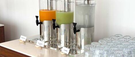 Eine Getränkestation mit drei Spendern, beschriftet mit 'Chai Tee', 'Grüner Tee' und 'Eiswasser'.