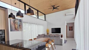 A modern kitchen with a central island, pendant lighting, and a ceiling fan. - Samui Luxury villas-BySamui Rental  (Bueang Sam Phan)