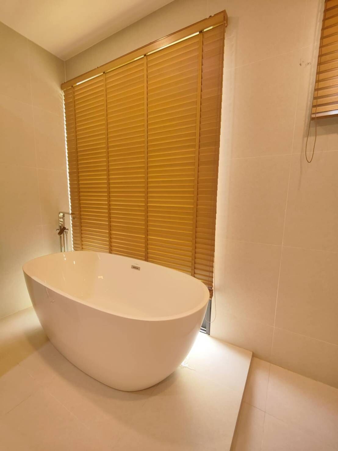 Une salle de bain moderne avec une baignoire sur pieds, des portes coulissantes en bois et des murs carrelés.