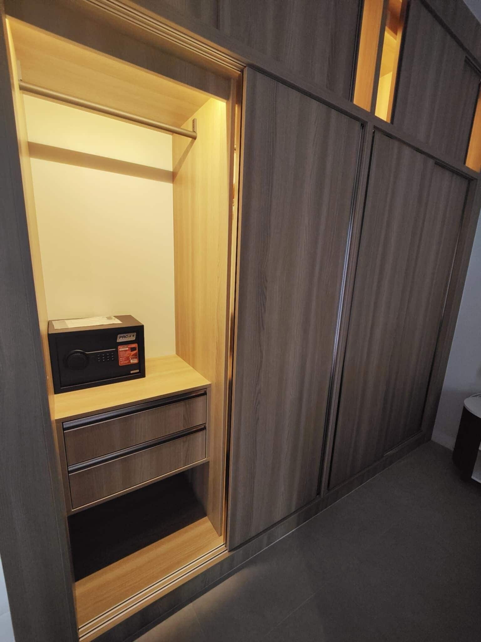 A walk-in closet with wooden shelving, a built-in radio, and a mirror.
