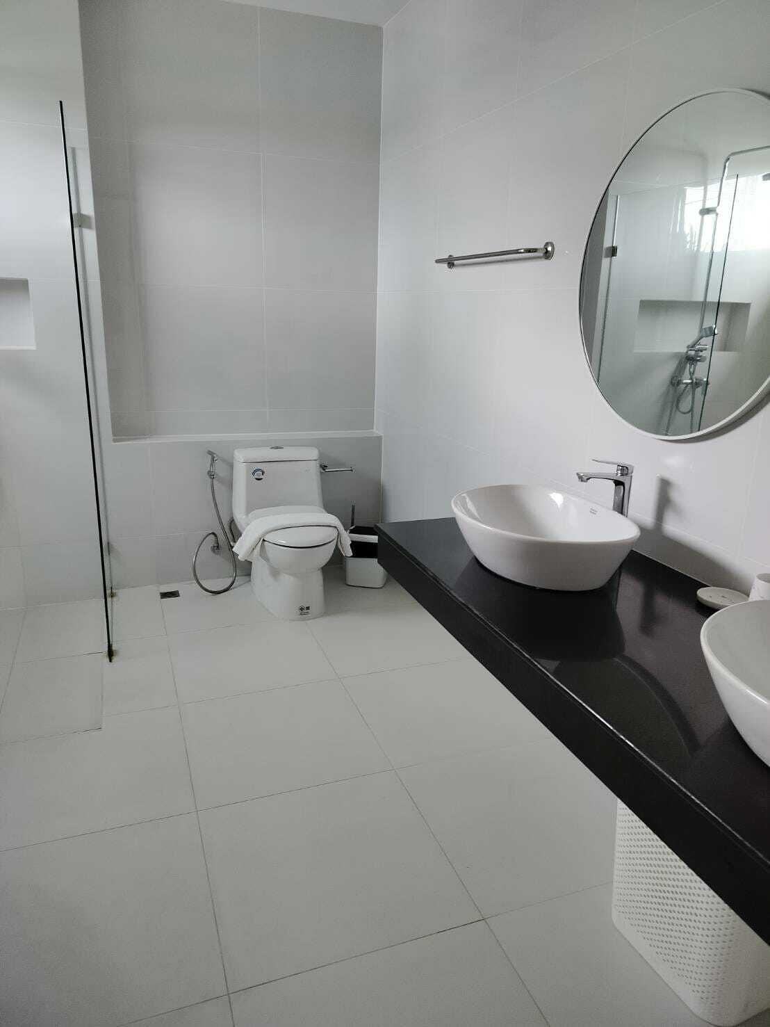 Une salle de bain moderne équipée de toilettes, d’un bidet et de deux lavabos.