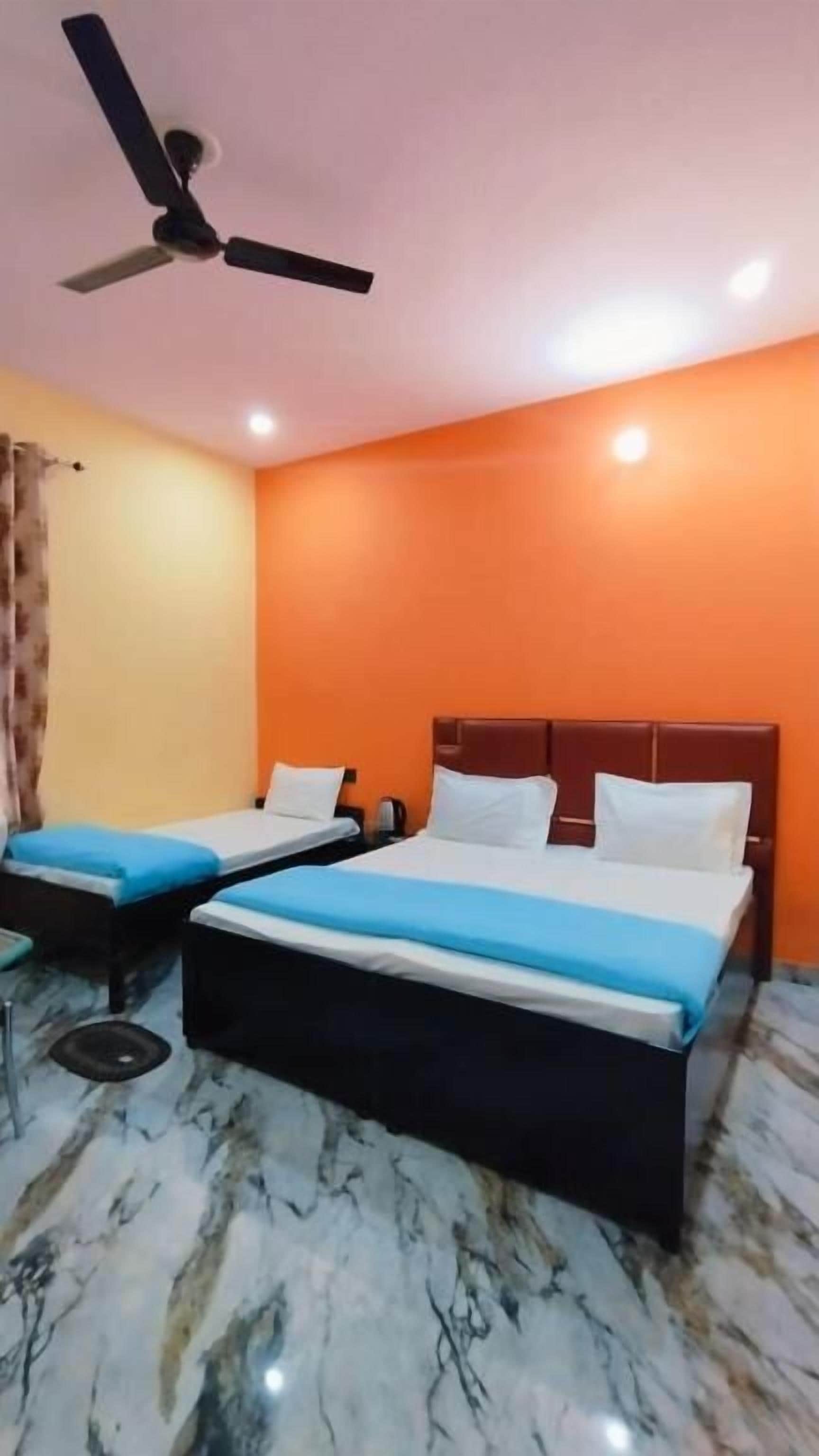 A hotel room with two beds, a ceiling fan, and marble flooring.