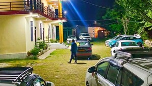 A parking area with cars and a building with balconies. - Yamunotri Darshan Resort By Preet rS (Rajgarhi)