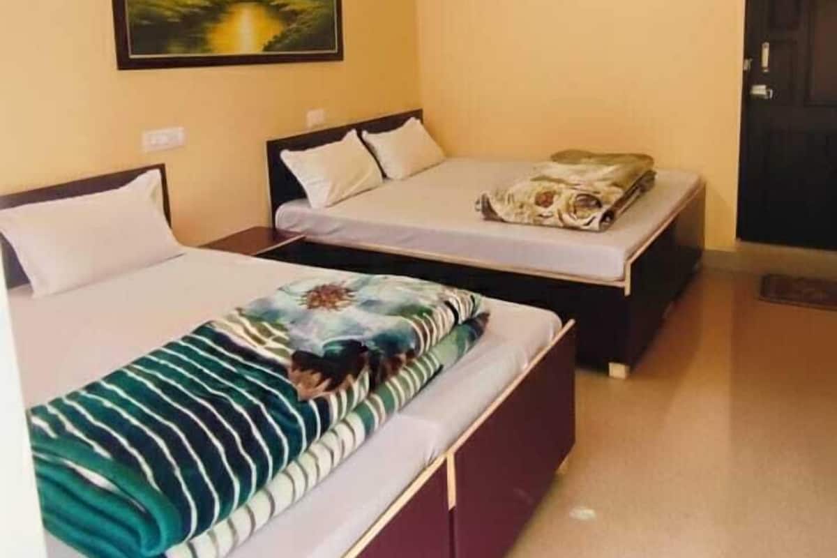 A bedroom with two beds, a ceiling fan, and a painting on the wall.