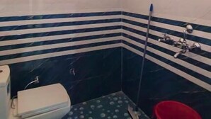 A small bathroom with a toilet, a shower, and a window. - Yamunotri Darshan Resort By Preet rS (Rajgarhi)