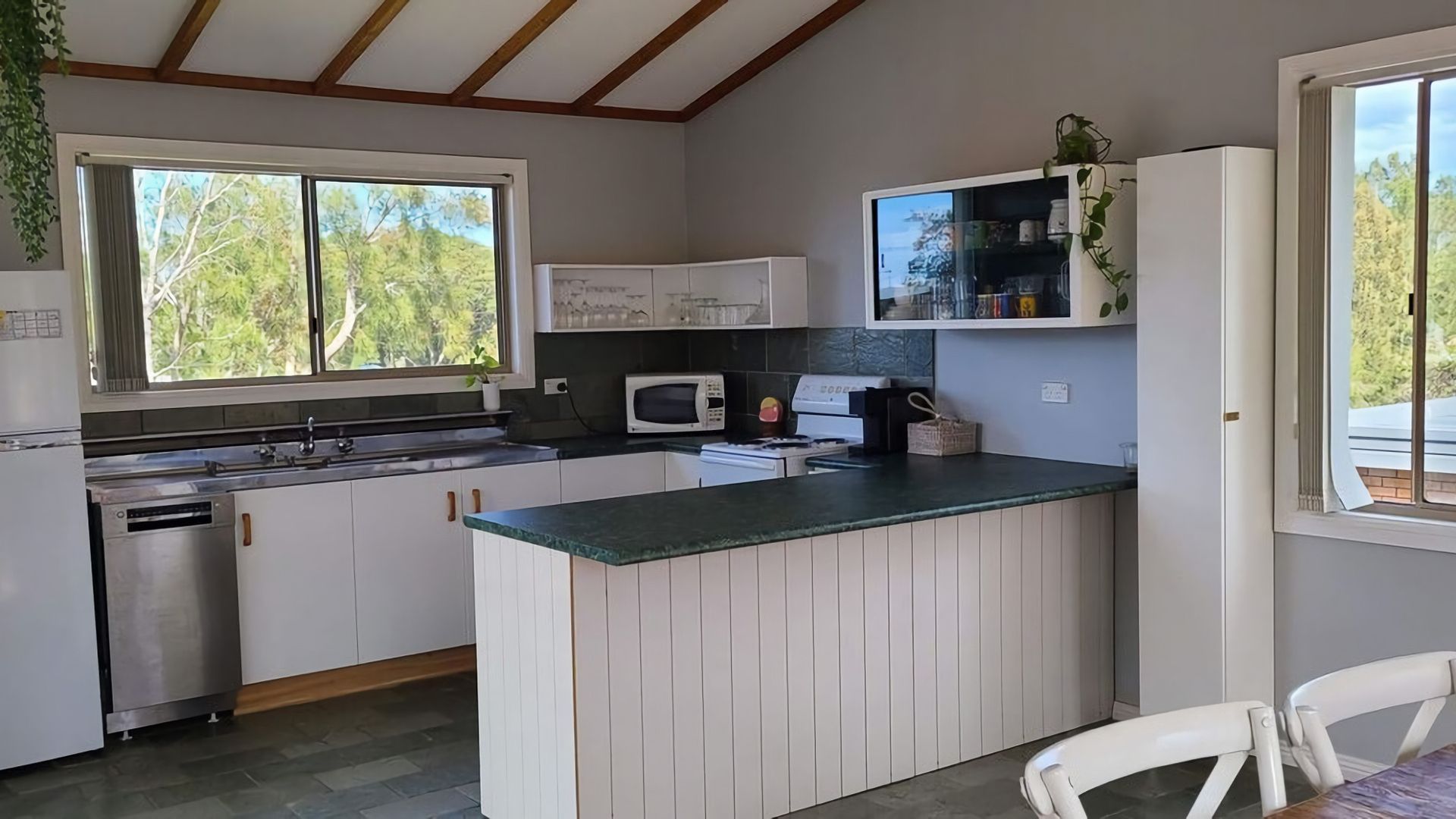 A kitchen with a central island, a microwave, and a sink.