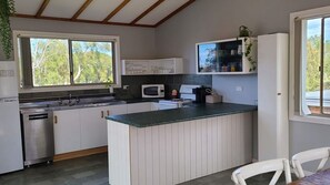 A kitchen with a central island, a microwave, and a sink.