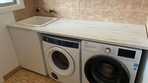 A compact laundry area with a washing machine and a sink.