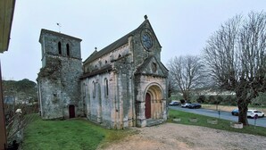 Une vieille église en pierre, dotée d’un clocher et de fenêtres en arc.