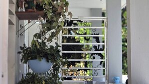 A balcony with potted plants and a white metal gate. - DUERMES CON LA NATURALEZA (Ramos)