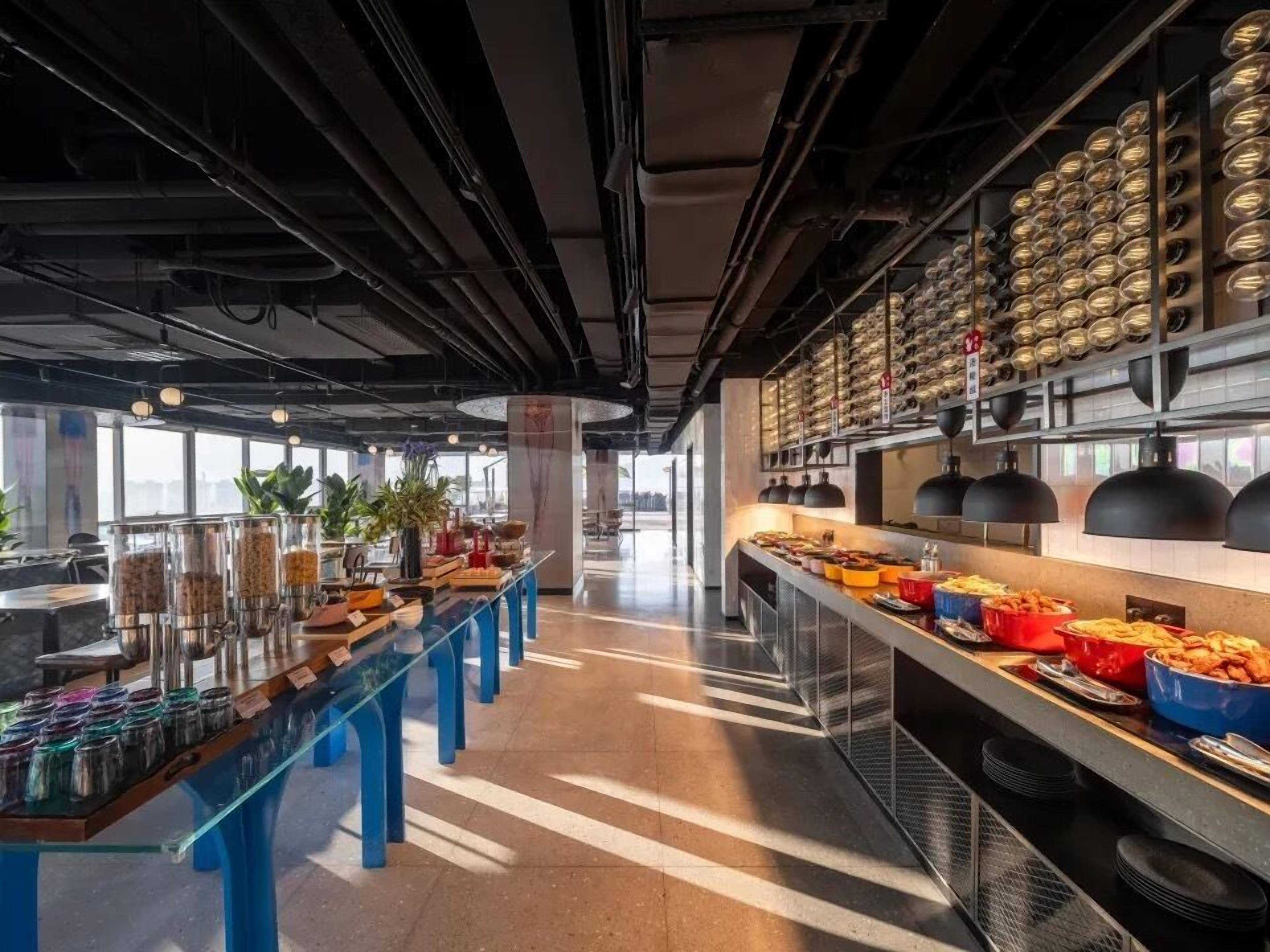 A modern kitchen area with a buffet setup, including various food containers and a long serving counter.